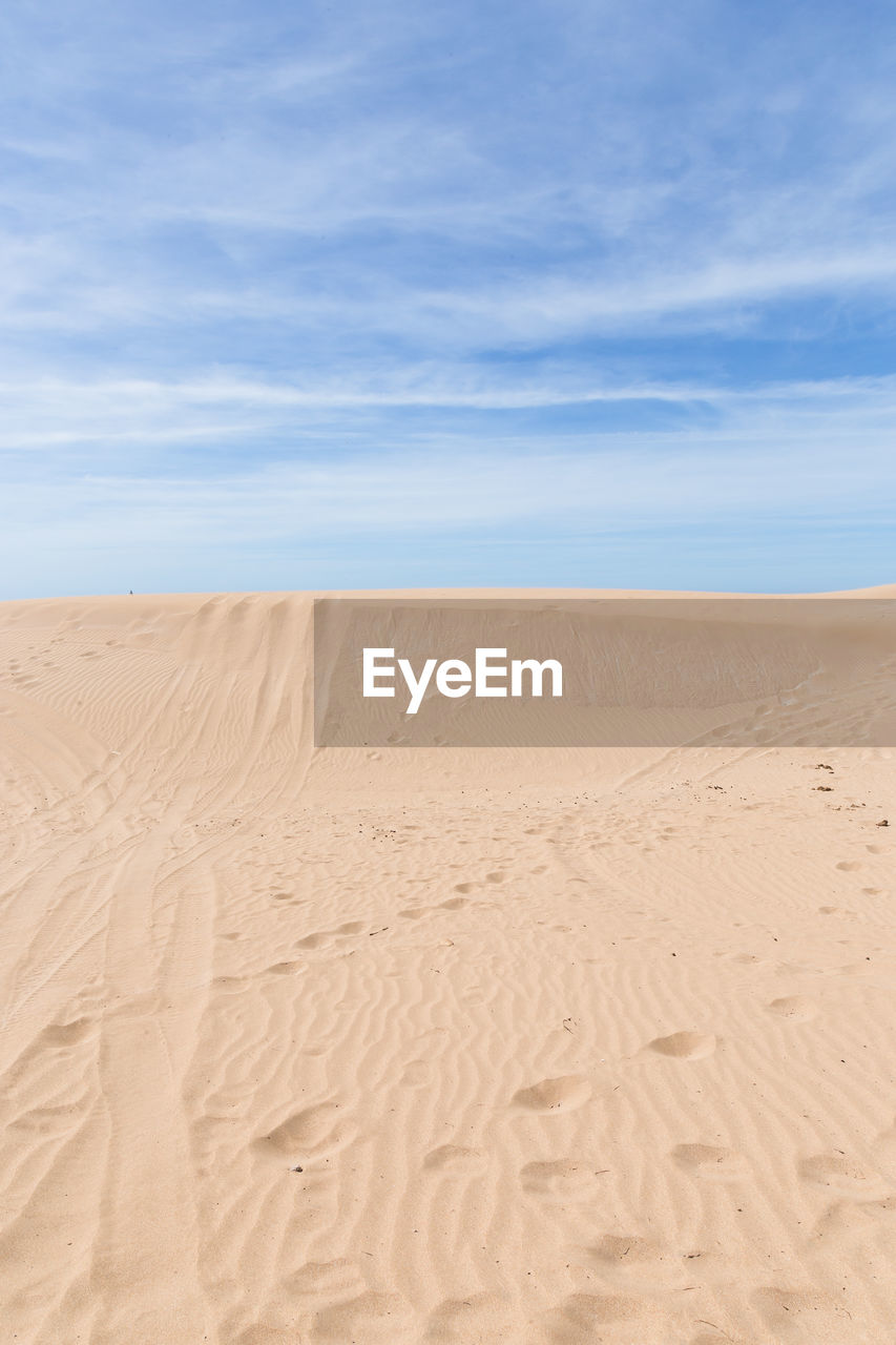 SCENIC VIEW OF SAND DUNE AGAINST SKY