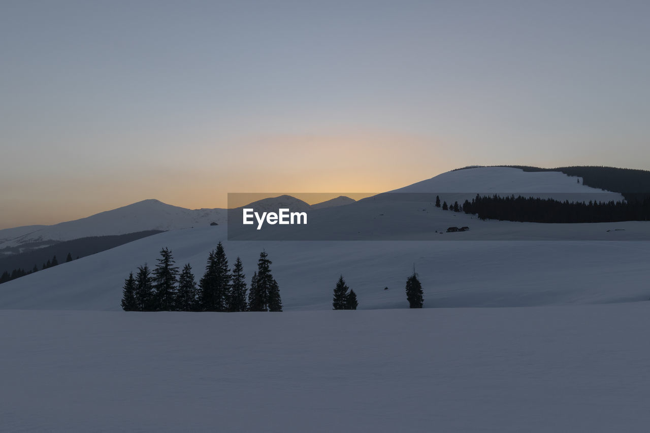 Scenic view of snowcapped mountains against sky during sunset