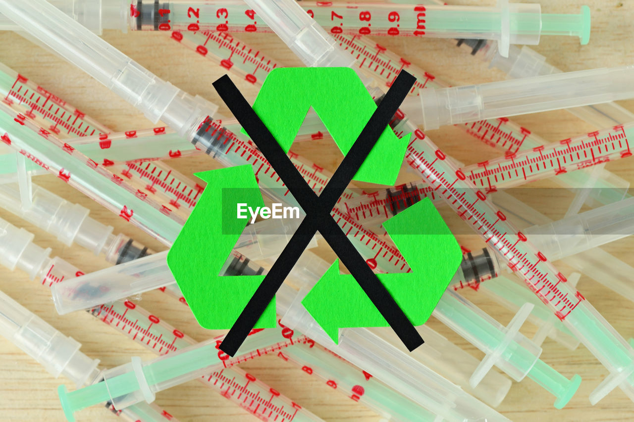 Digital composite image of symbols on syringes at table