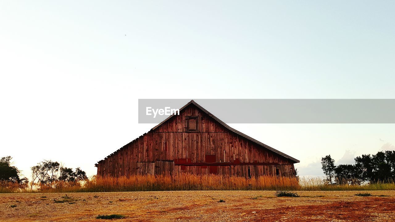 Barn on field against clear sky