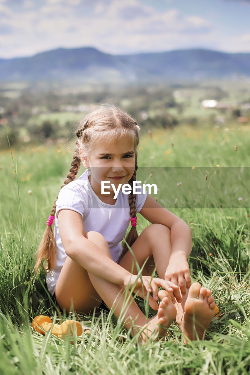 GIRL SITTING ON FIELD