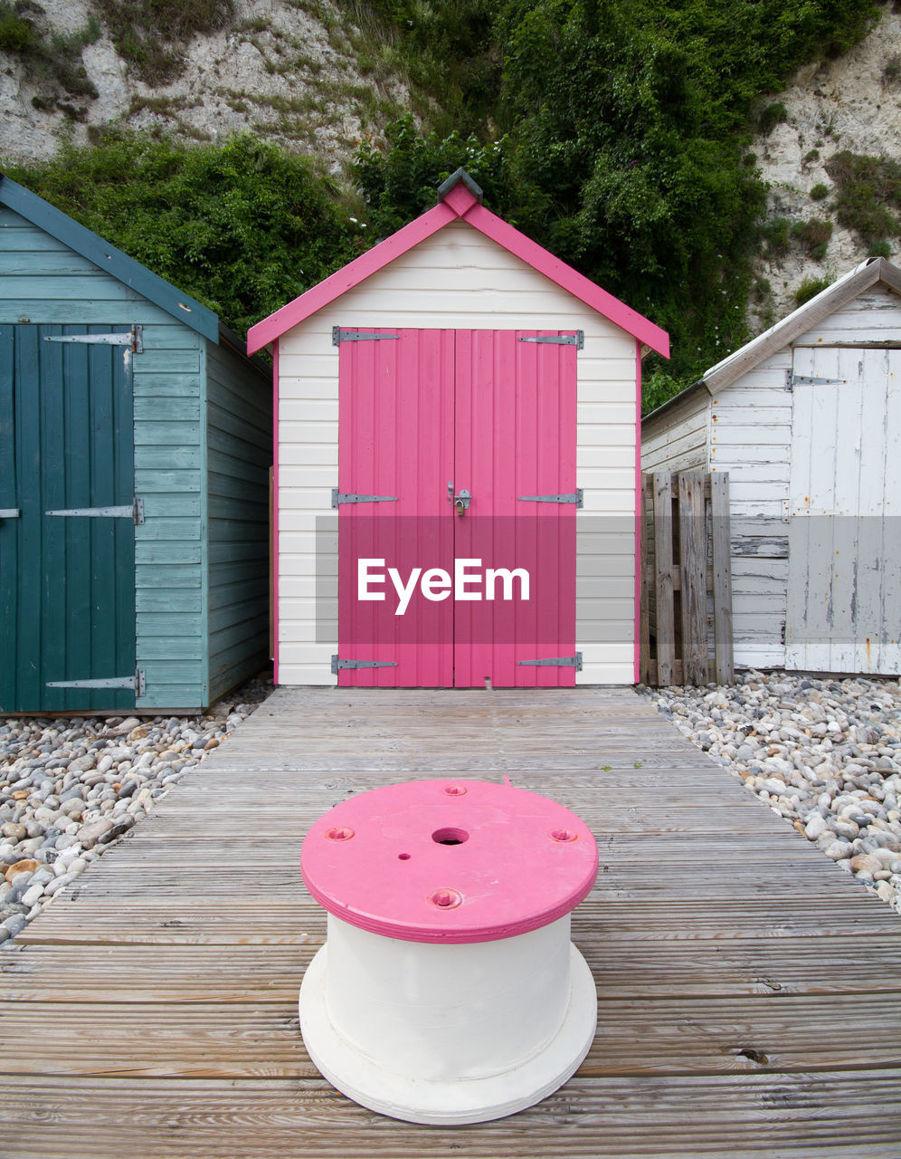 Pink stool against beach hut