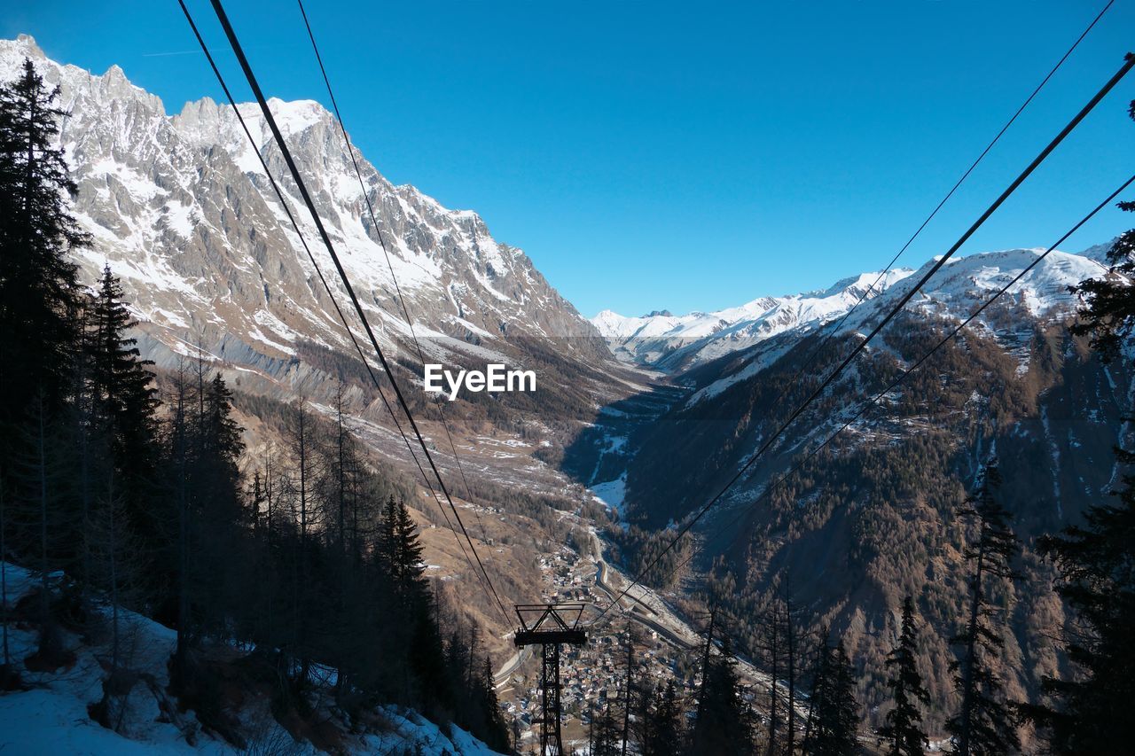 Scenic view of snowcapped mountains against clear blue sky