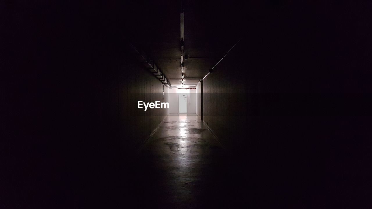 Empty corridor in illuminated building