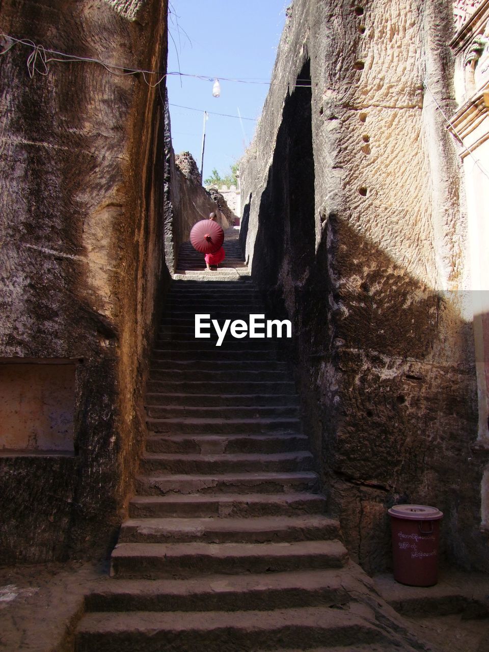 Low angle view of monk with umbrella standing on steps