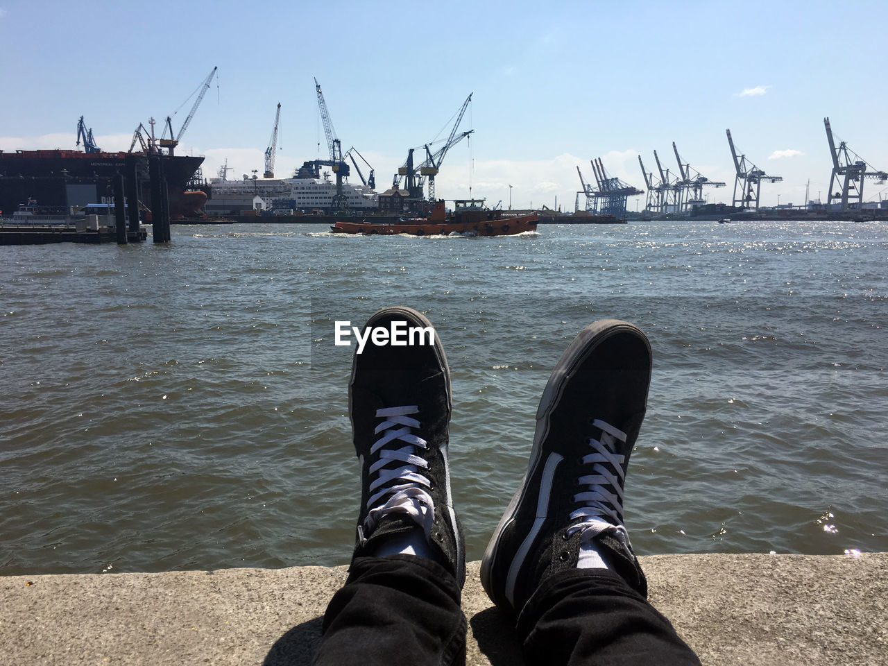 Low section of man sitting against harbor