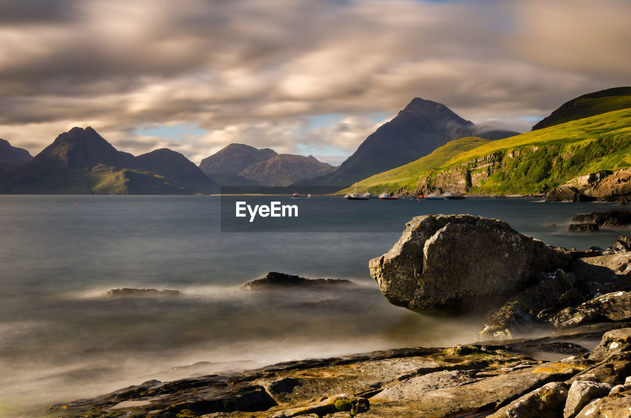 Scenic view of sea and mountains against sky