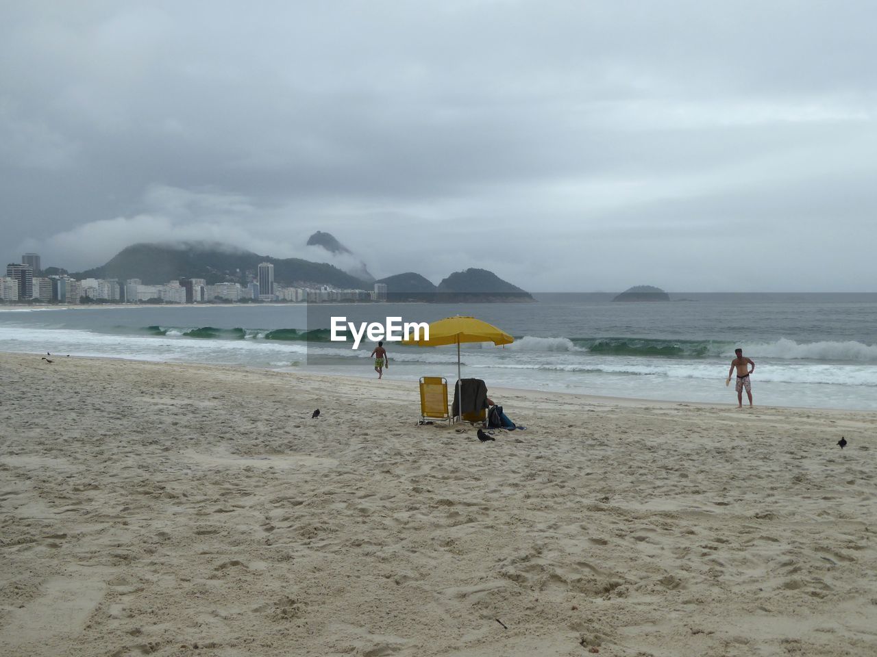 PEOPLE ON BEACH AGAINST SKY