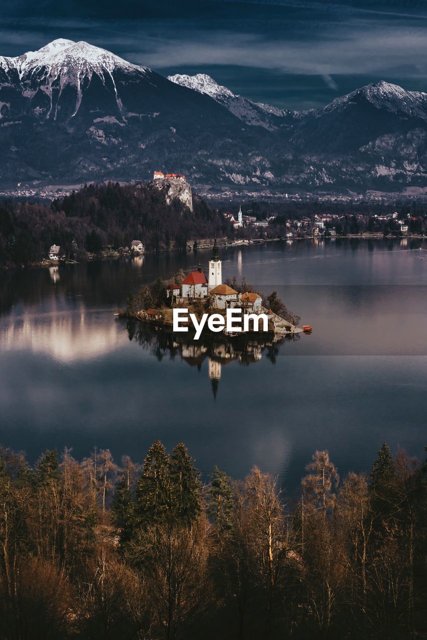 Scenic view of lake by buildings against sky