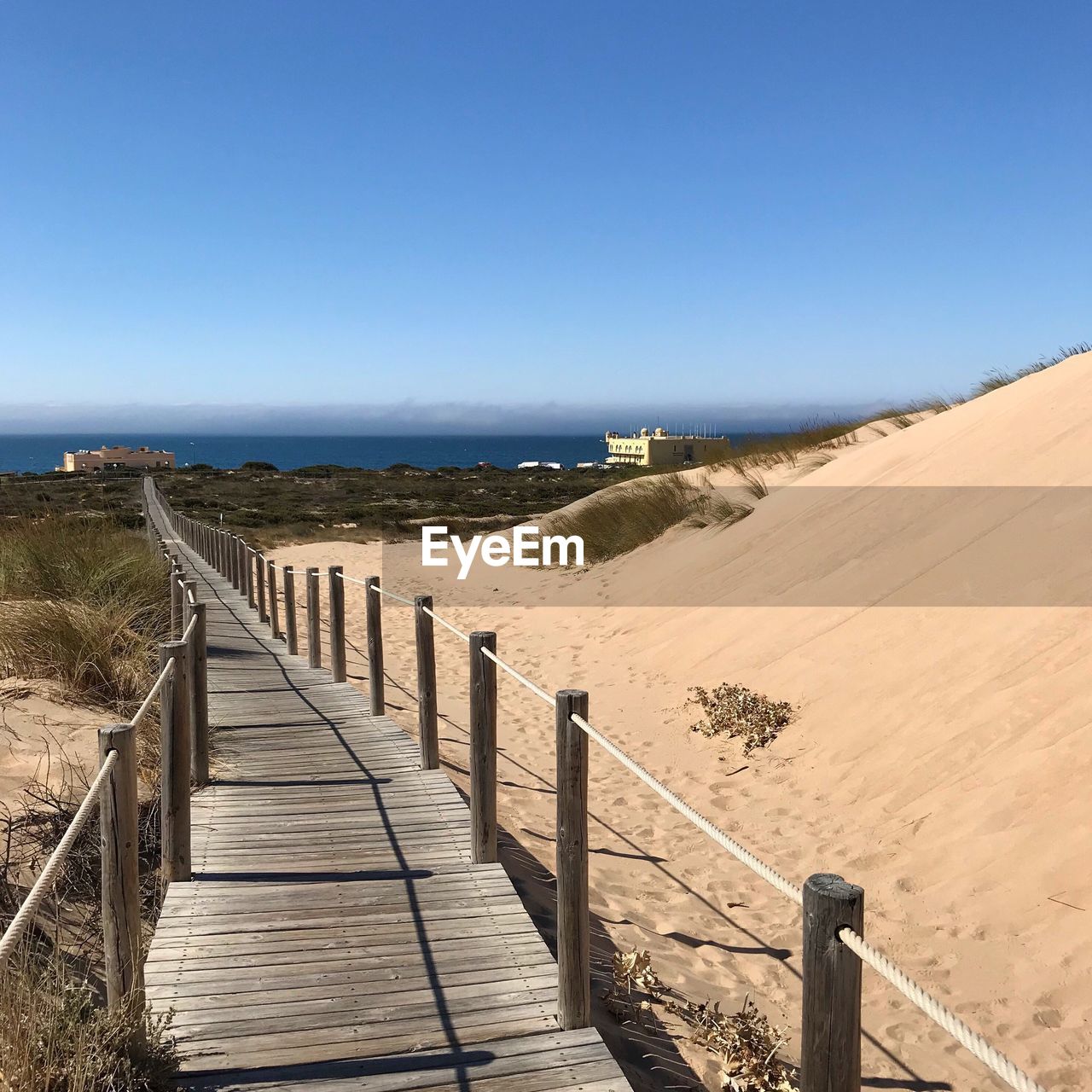 Scenic view of beach against clear blue sky