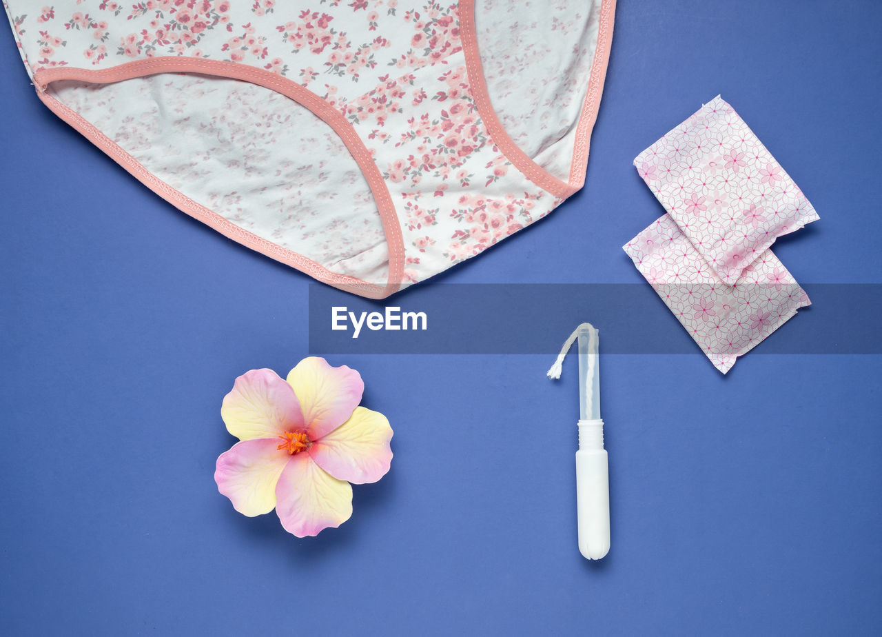 Women's hygiene related objects on a blue background.