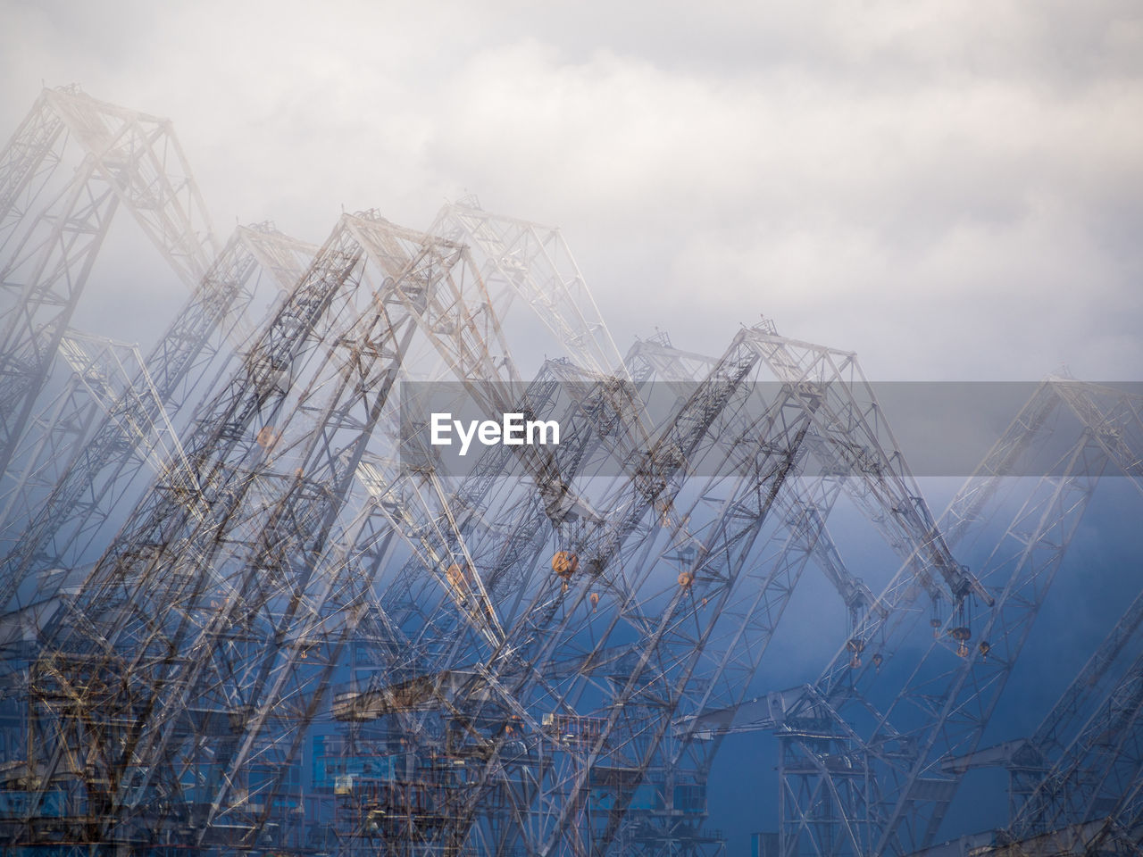 LOW ANGLE VIEW OF CRANE AT CONSTRUCTION SITE AGAINST SKY