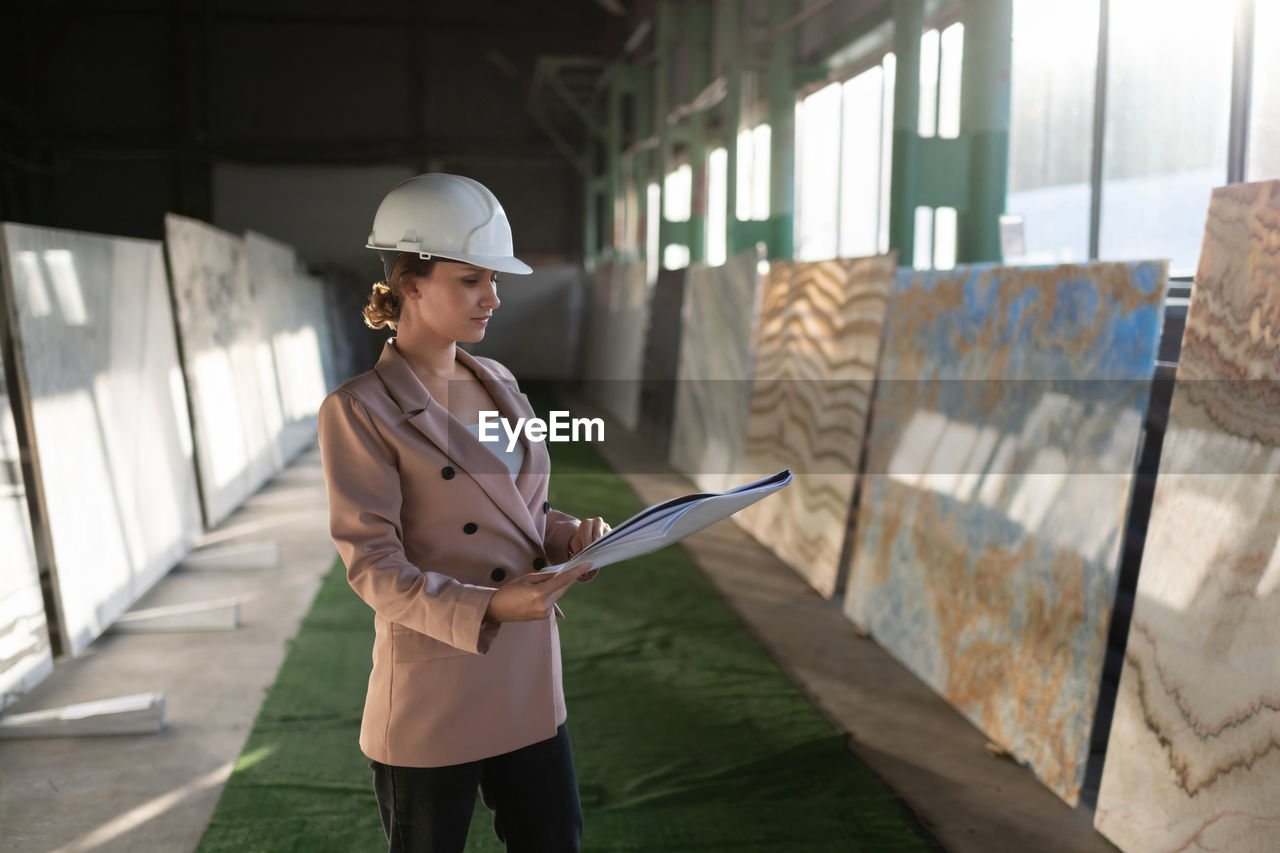 Concentrate engineer reading blueprint in warehouse