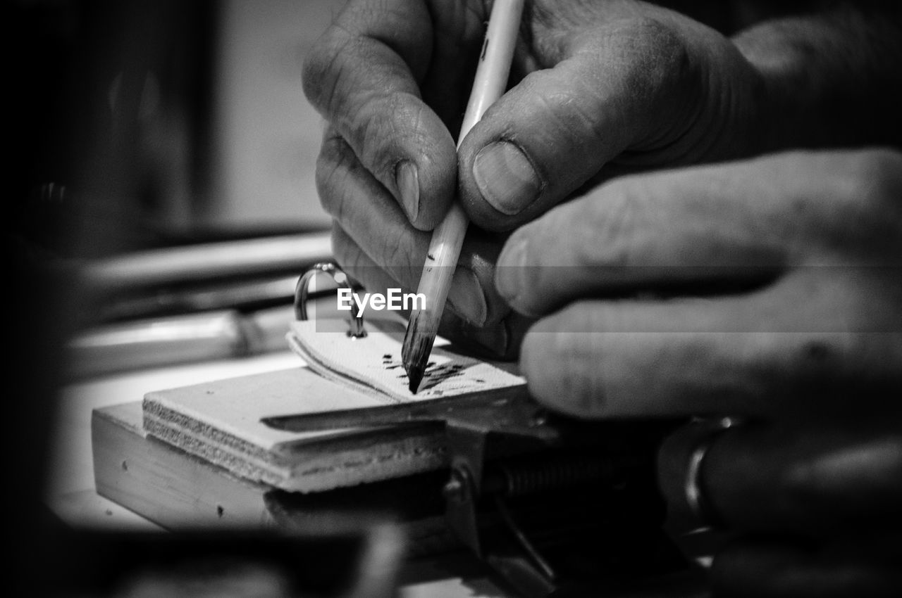 Cropped image of craftsperson writing on leather