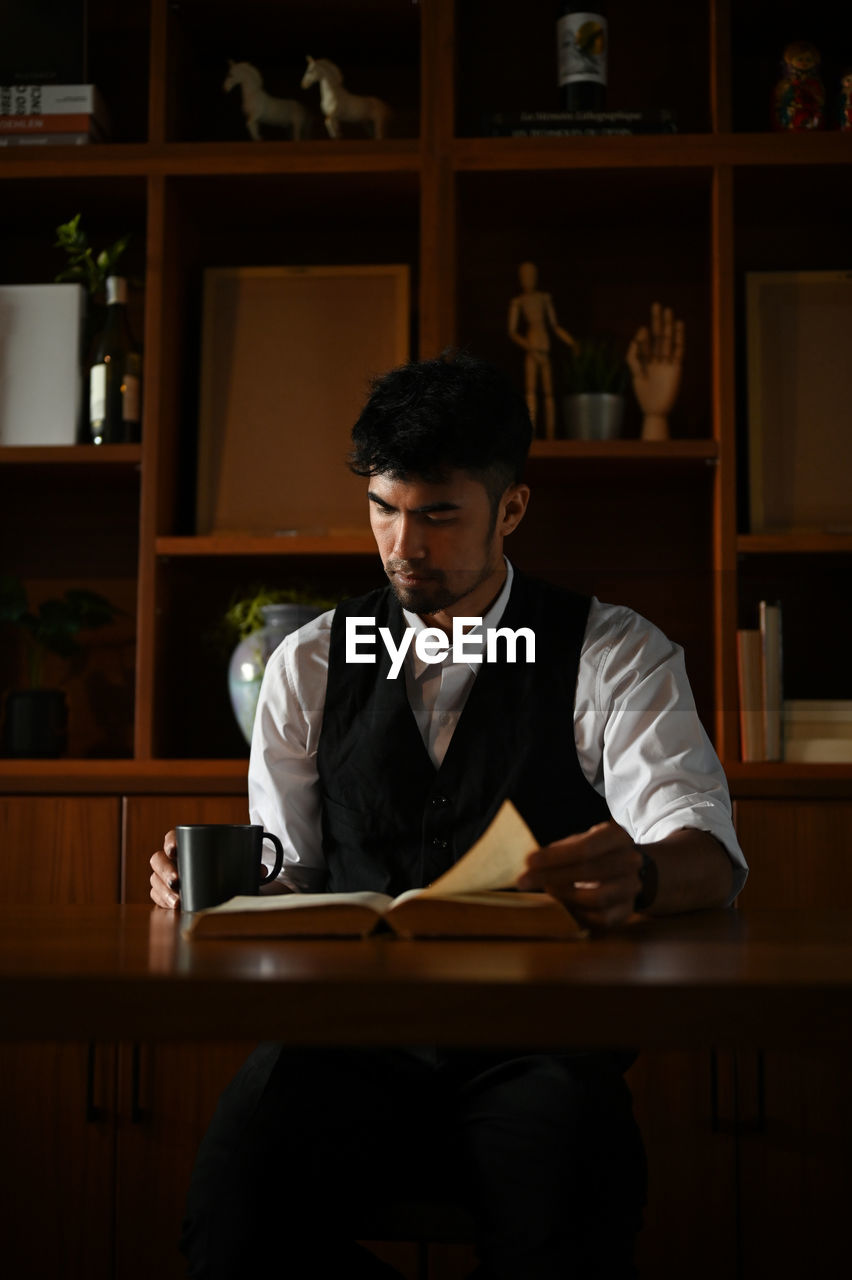 Businessman reading book at office