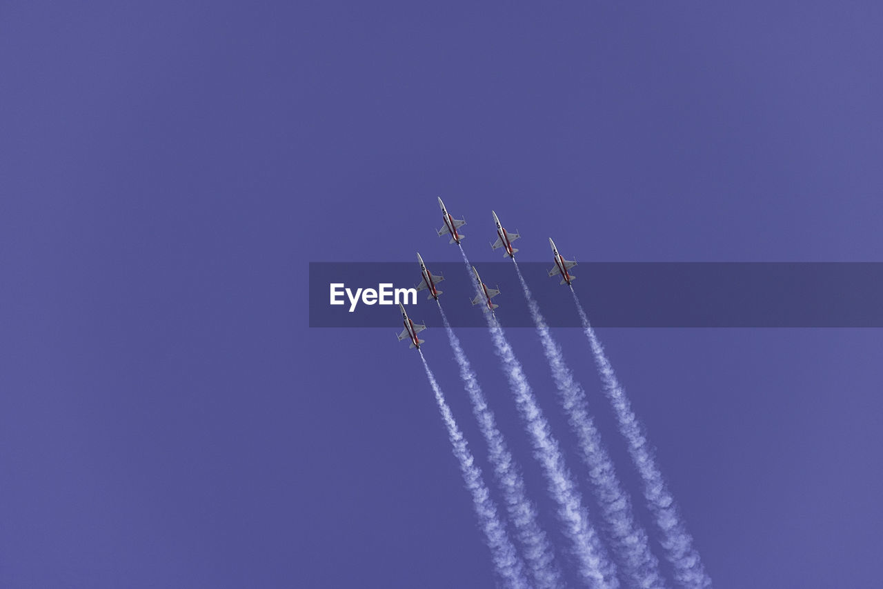 air vehicle, airplane, air show, mode of transportation, transportation, sky, vapor trail, on the move, flying, smoke, motion, blue, cloud, fighter plane, plane, speed, clear sky, teamwork, low angle view, cooperation, no people, nature, line, mid-air, performance, skill, day, military airplane, travel, copy space, military, wing, outdoors, order, arrangement, aerobatics, sunny, stunt