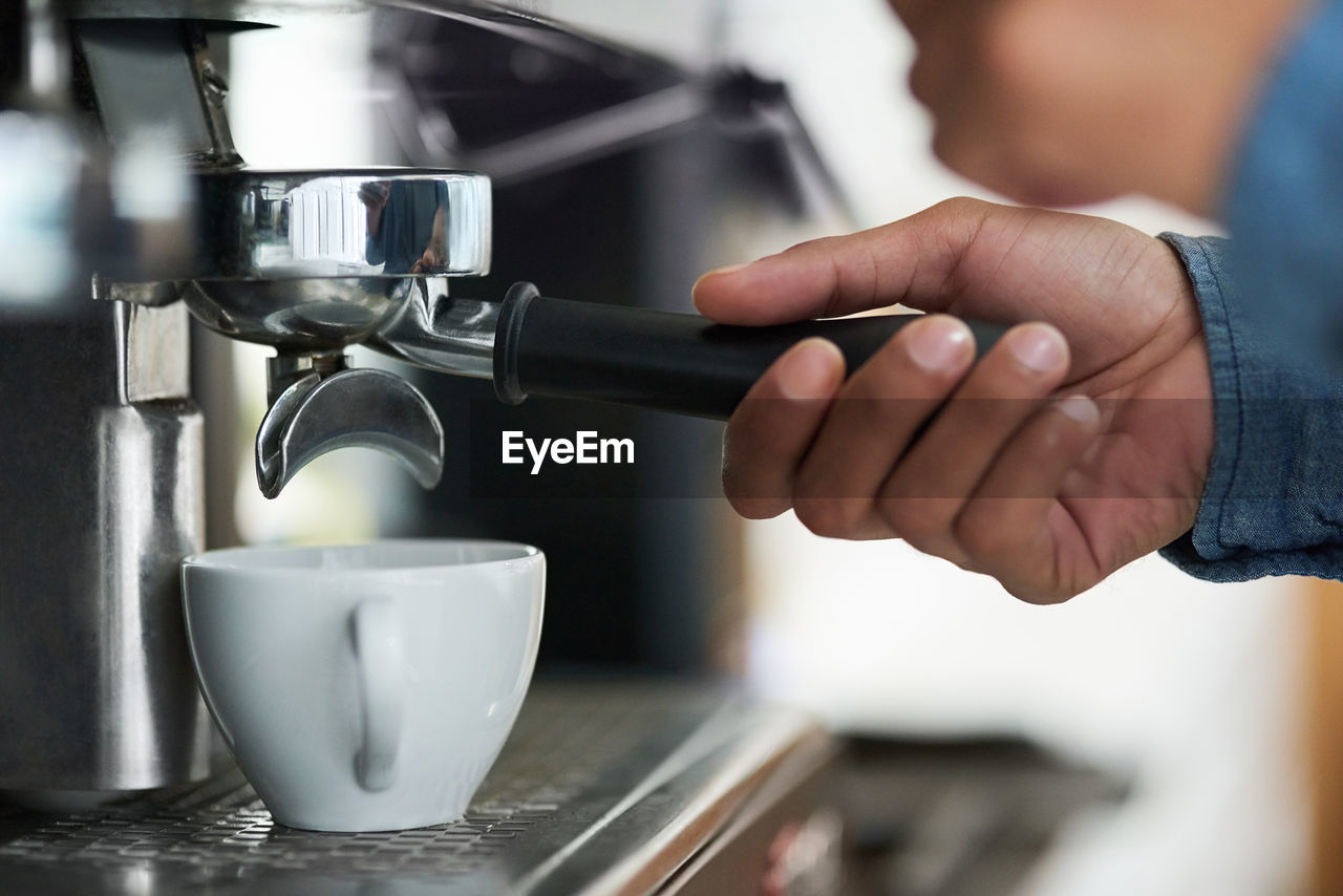 midsection of man pouring coffee