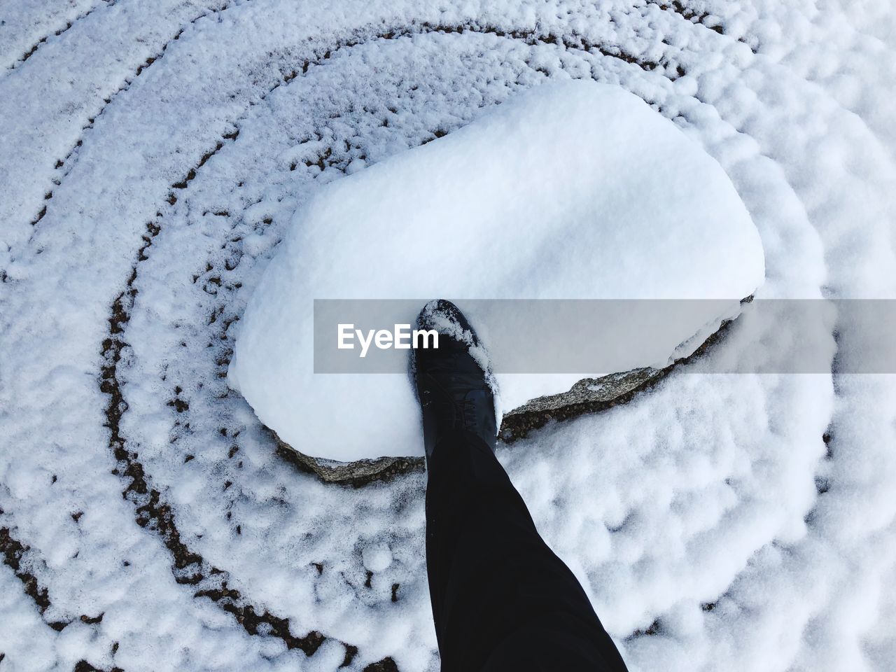 LOW SECTION OF PERSON ON SNOW COVERED SNOWED DURING WINTER