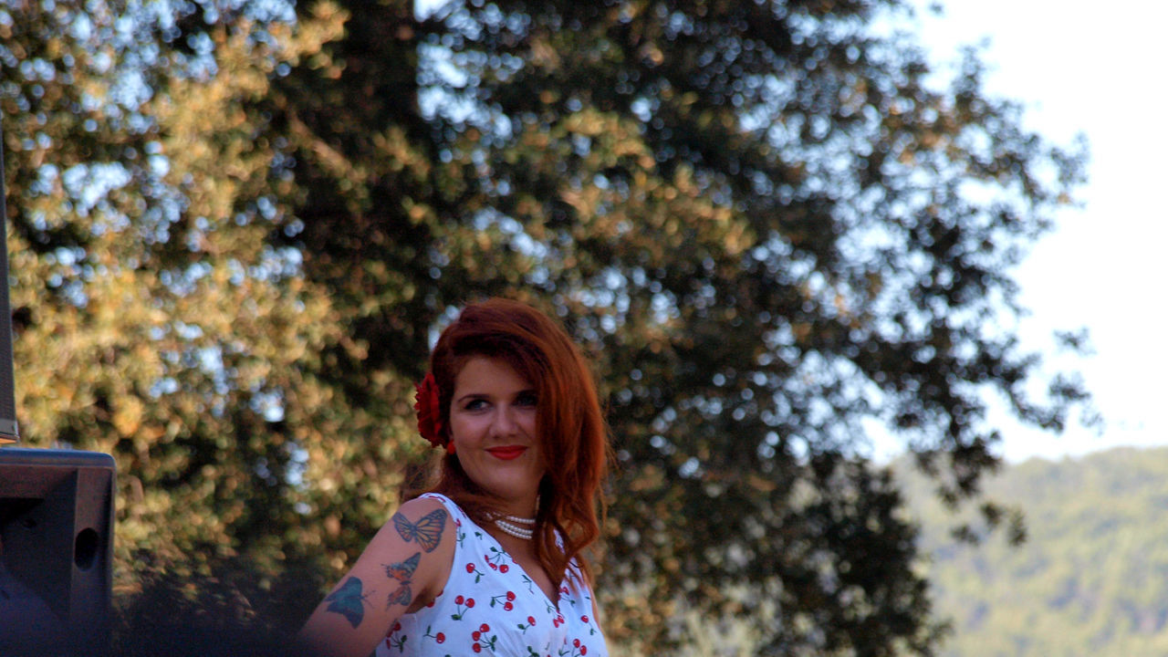 CLOSE-UP PORTRAIT OF YOUNG WOMAN AGAINST TREES