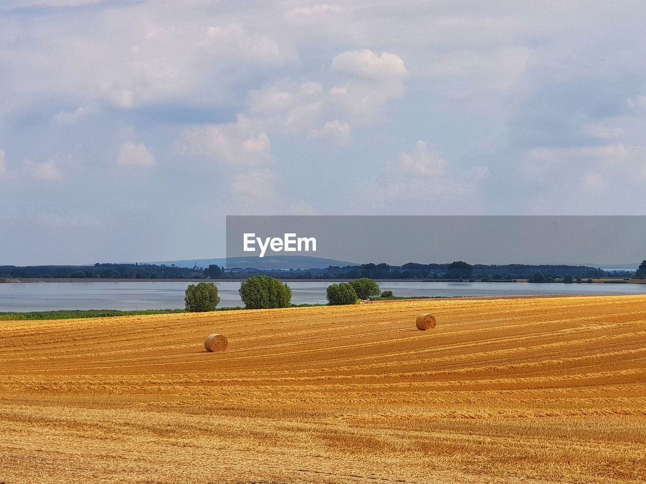 Hay bales on field against sky