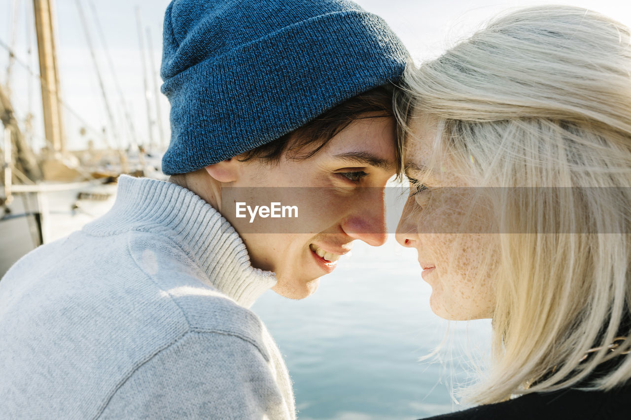 Smiling young couple face to face at harbor