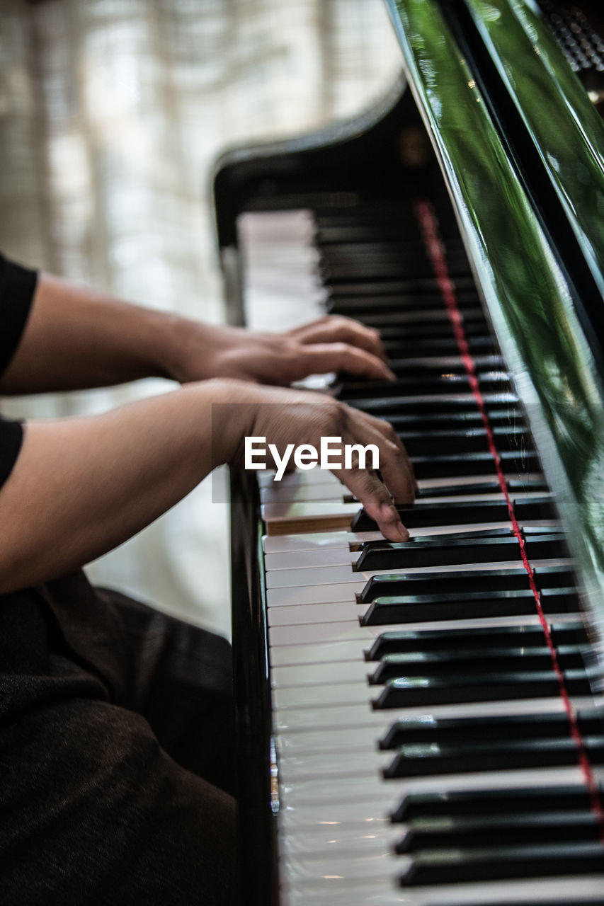 Midsection of man playing piano