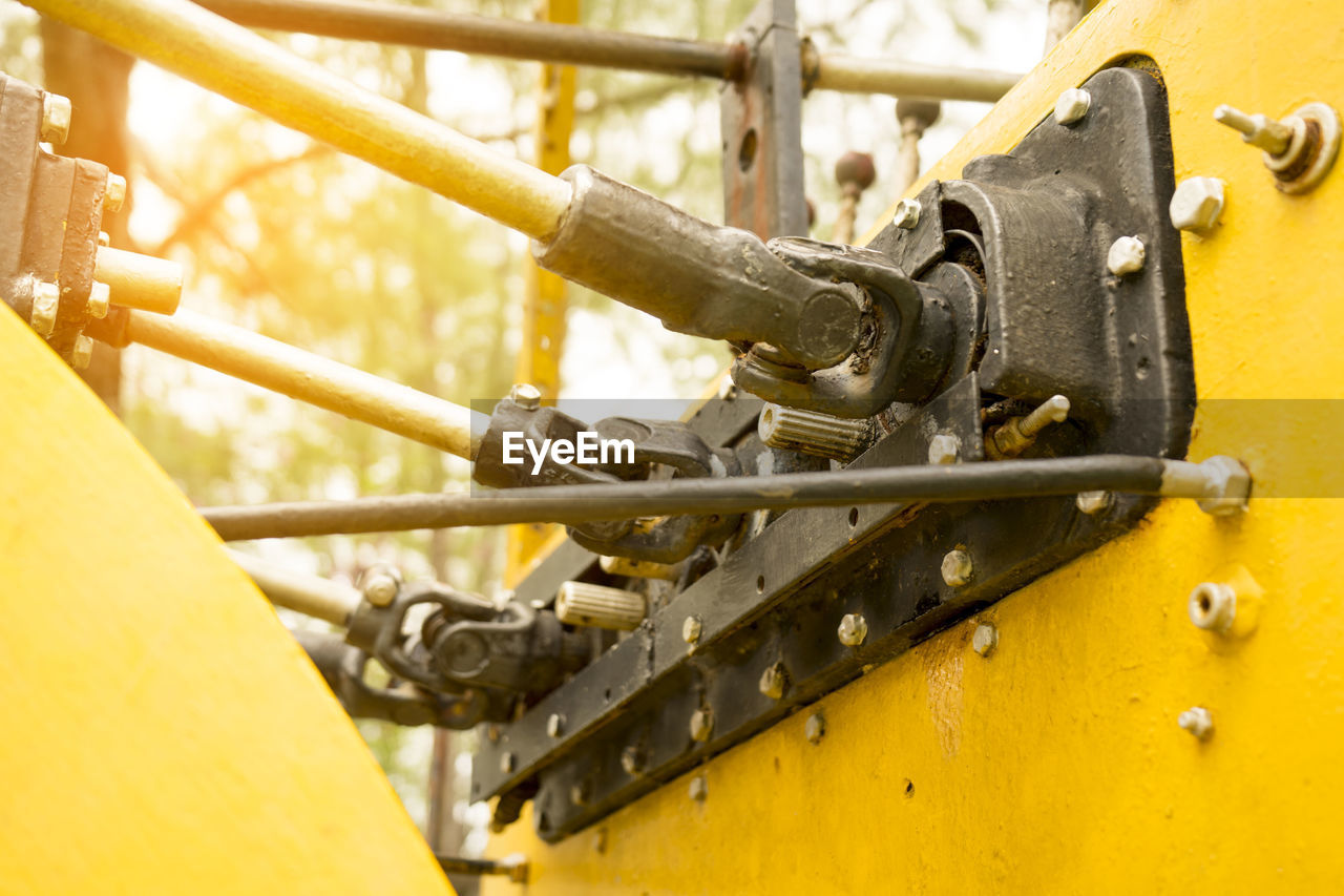 Close-up of yellow machine part outdoors