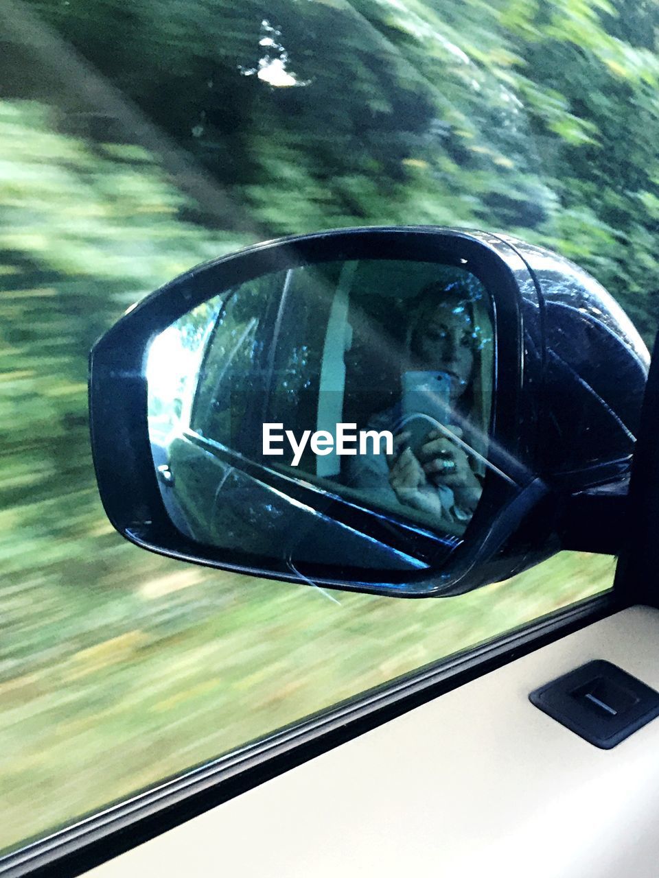 REFLECTION OF SIDE-VIEW MIRROR OF CAR ON WINDSHIELD