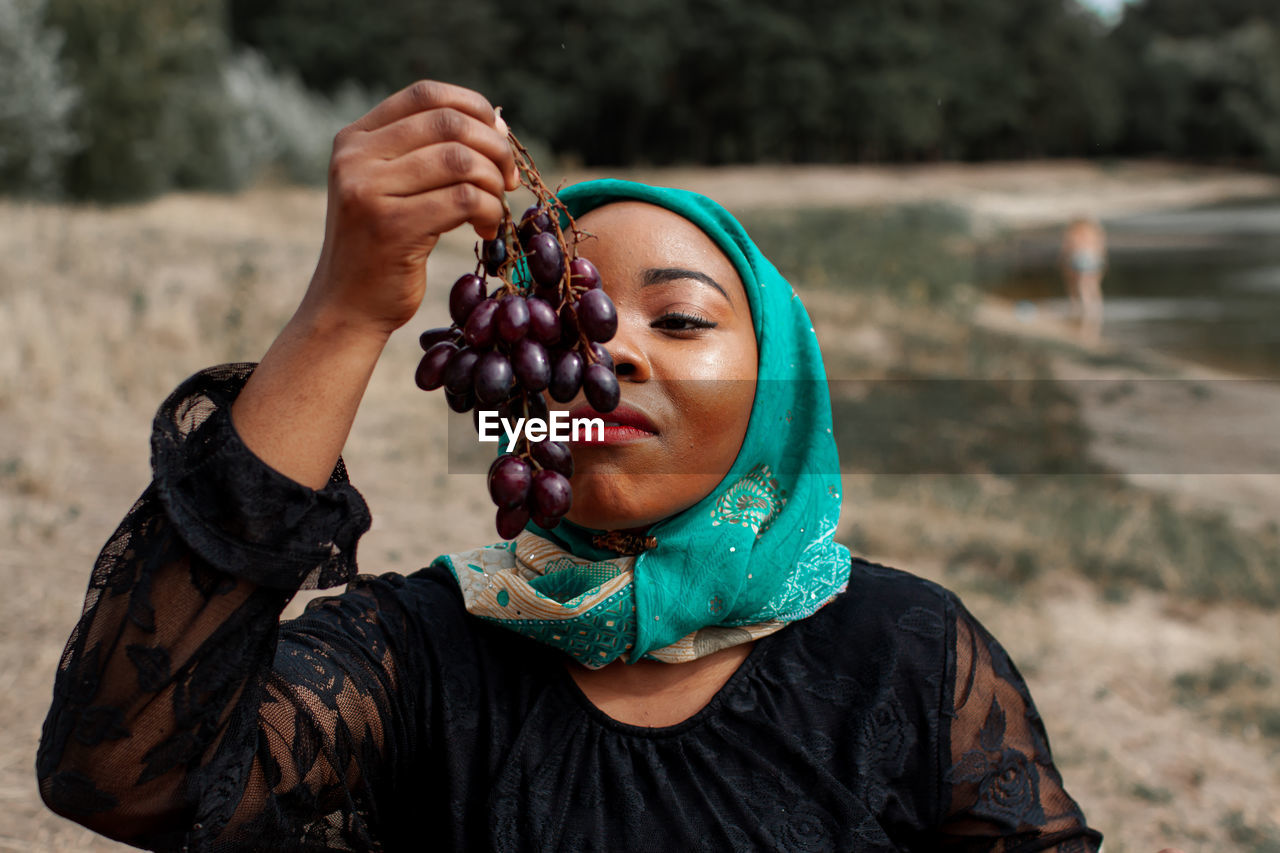 Young african woman eating grapes outdoor