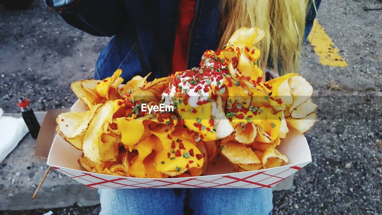 Midsection of woman with potato chips