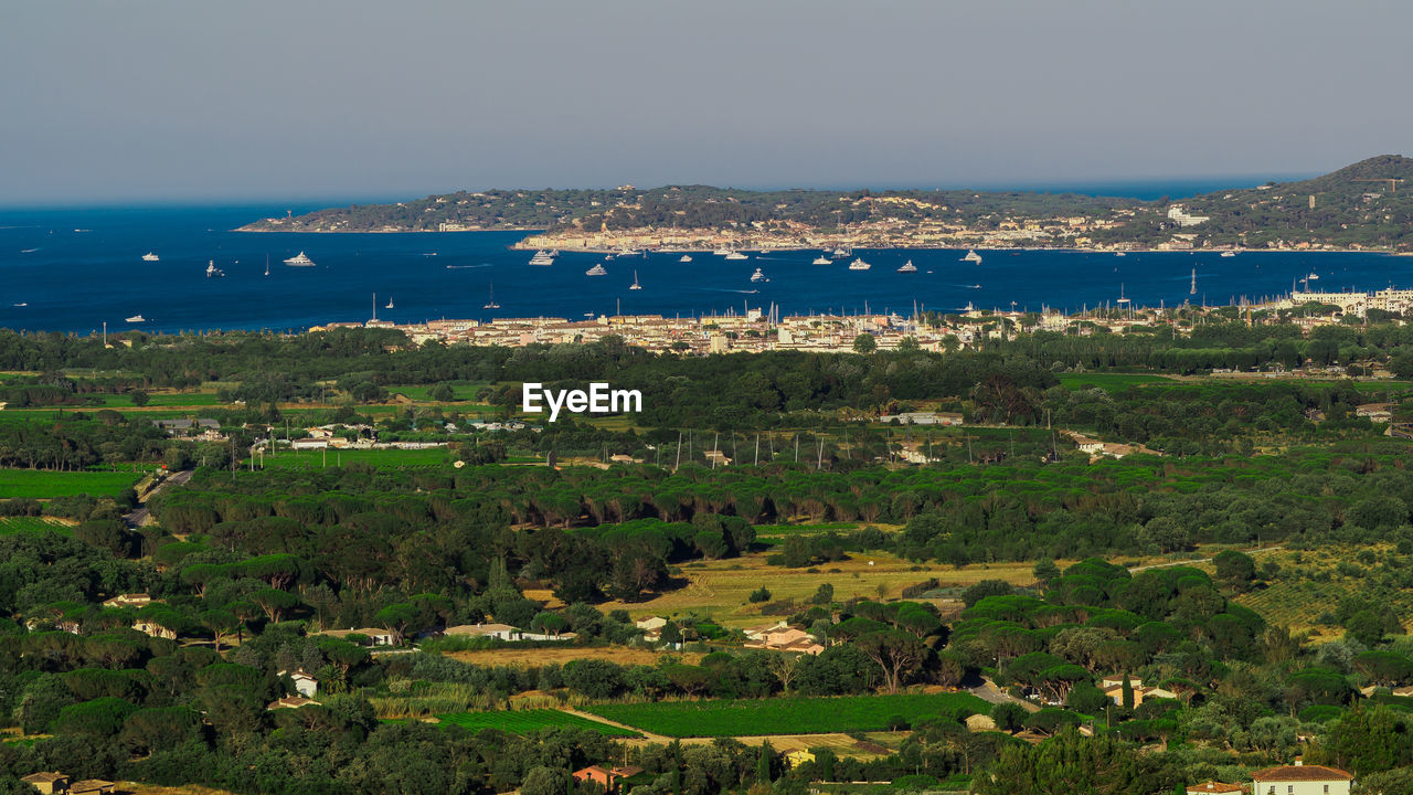 HIGH ANGLE VIEW OF TREES AND SEA AGAINST SKY