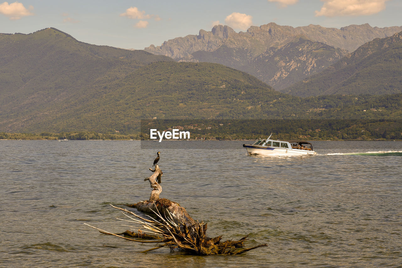 SCENIC VIEW OF SEA AGAINST MOUNTAINS