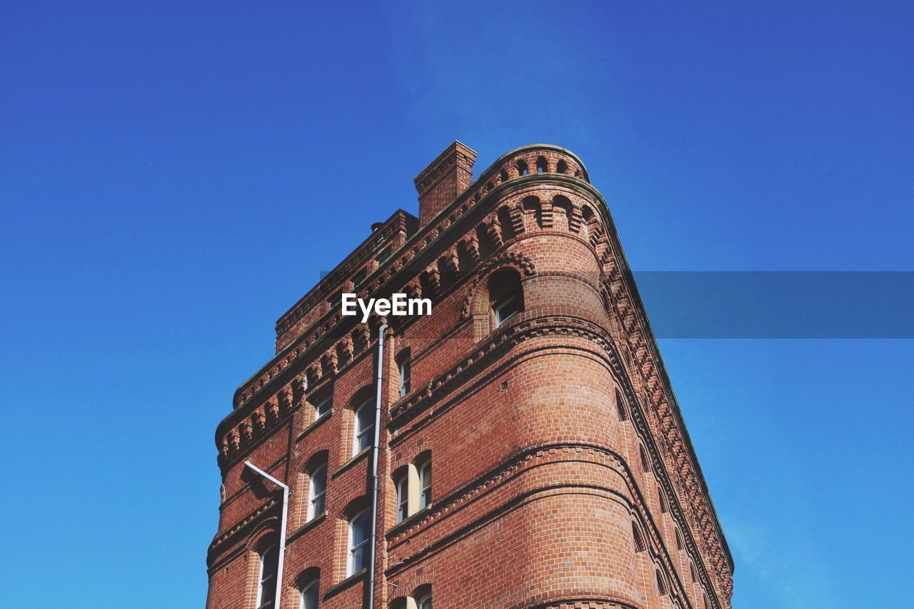 Low angle view of building against clear blue sky