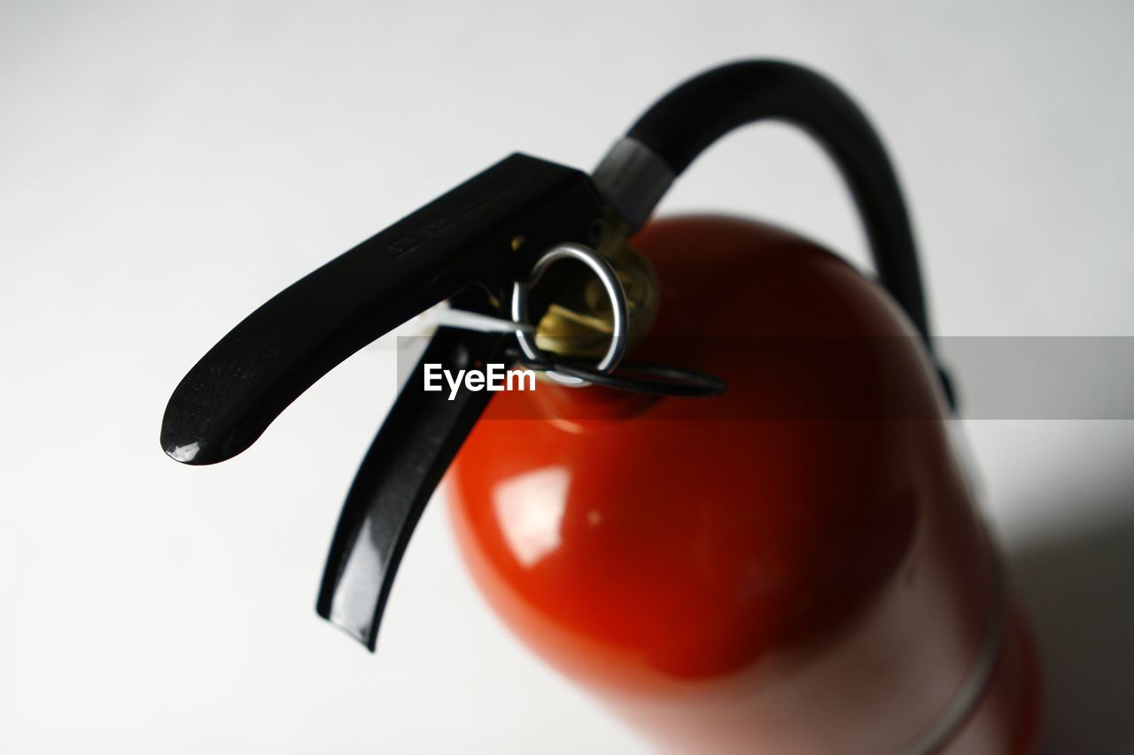 Close-up of fire extinguisher against white background