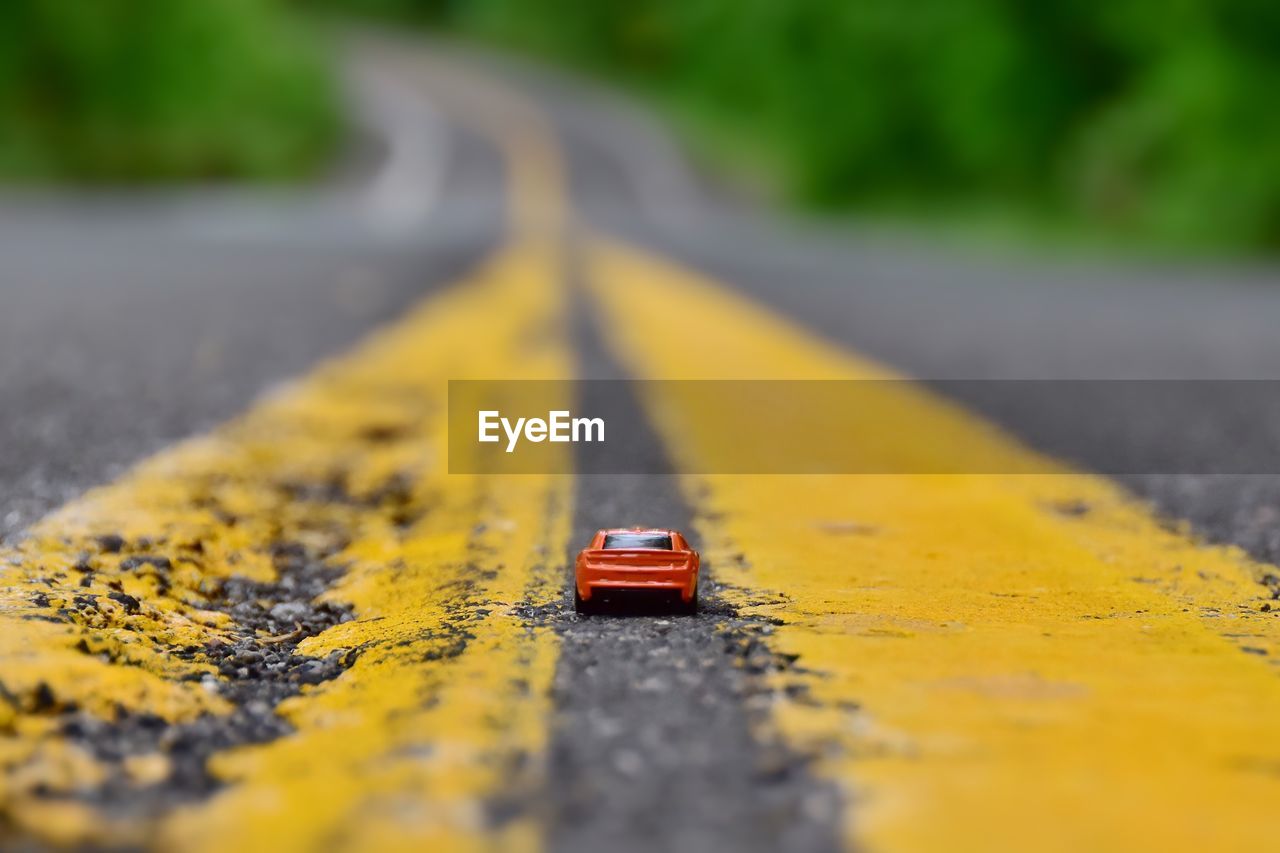 Close-up of red toy car on road