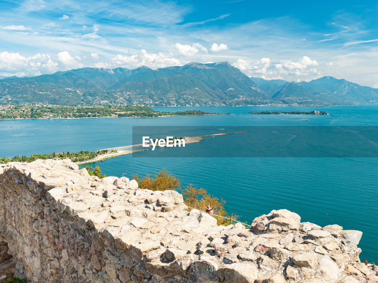 Lake garda and south alps peaks from the rocca di manerba ruins wall, manerba del garda, italy