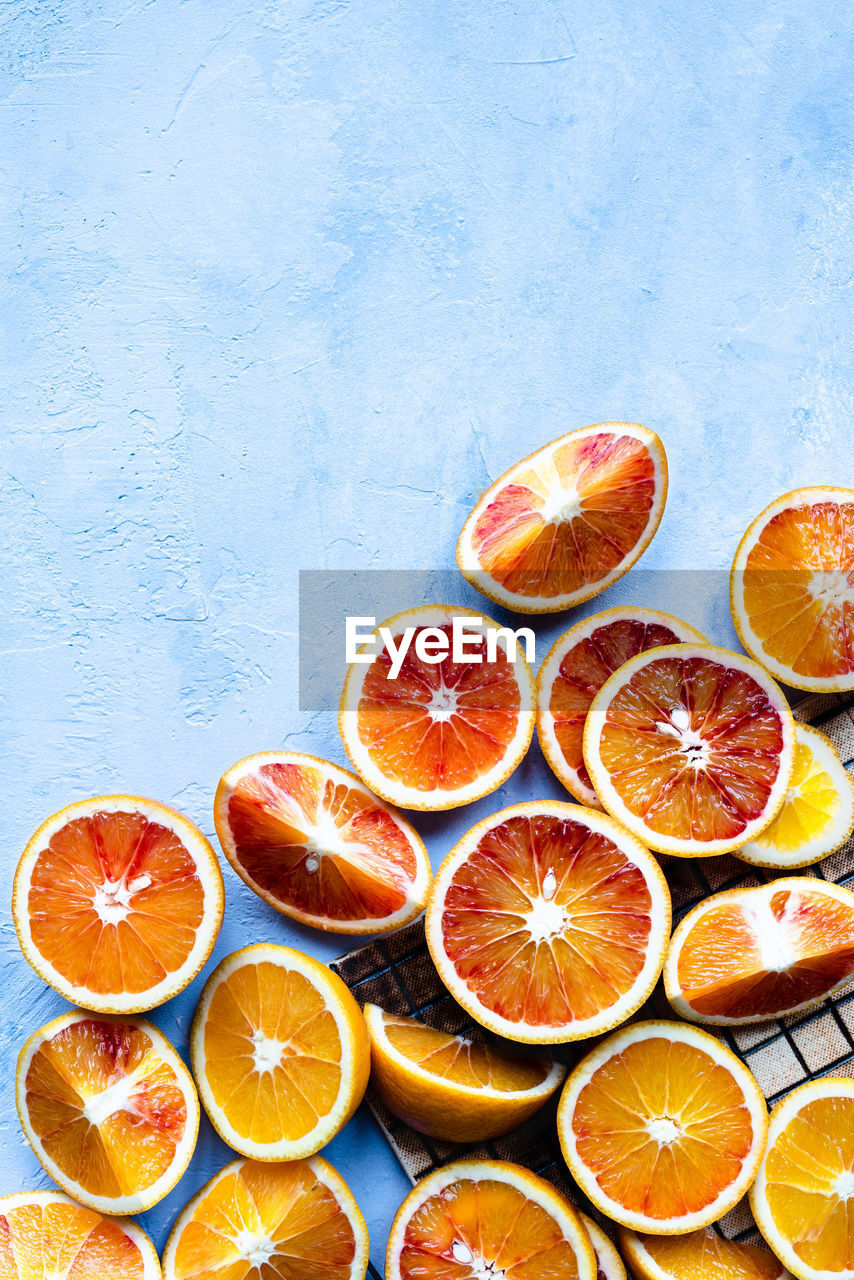 DIRECTLY ABOVE SHOT OF ORANGE FRUIT ON TABLE AGAINST GRAY BACKGROUND