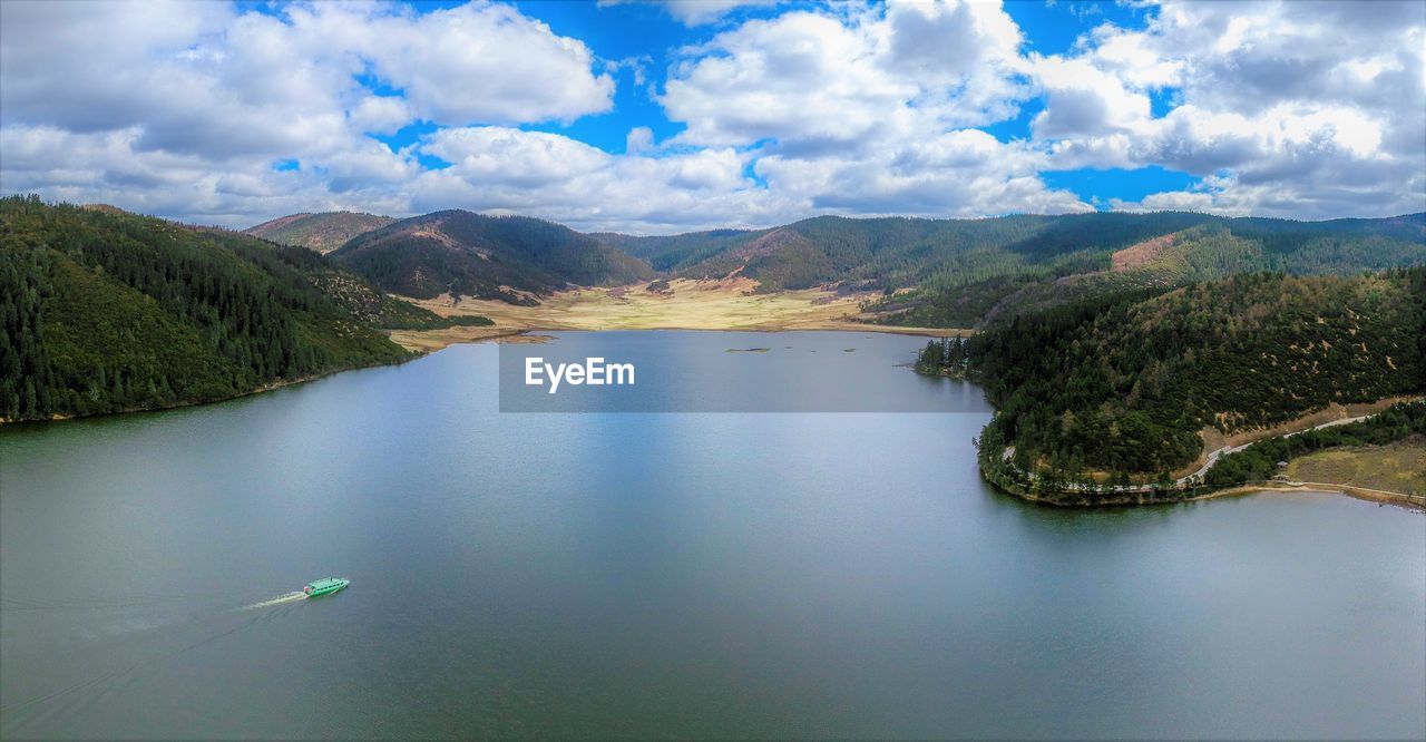 SCENIC VIEW OF LAKE BY MOUNTAIN AGAINST SKY