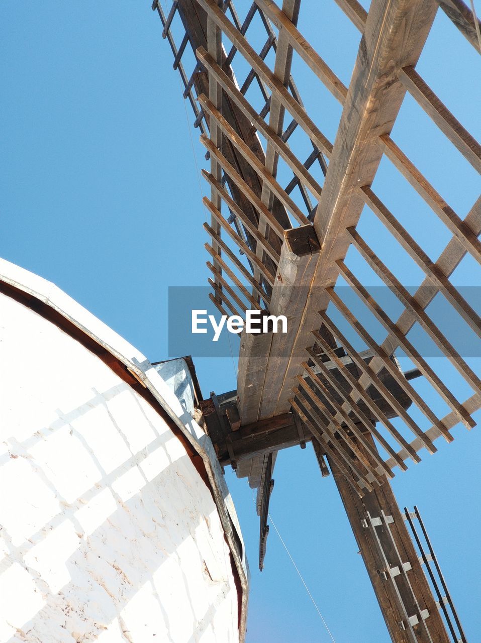 Low angle view of windmill against clear blue sky