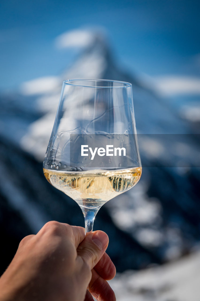 CLOSE-UP OF PERSON HAND HOLDING GLASS OF WINE