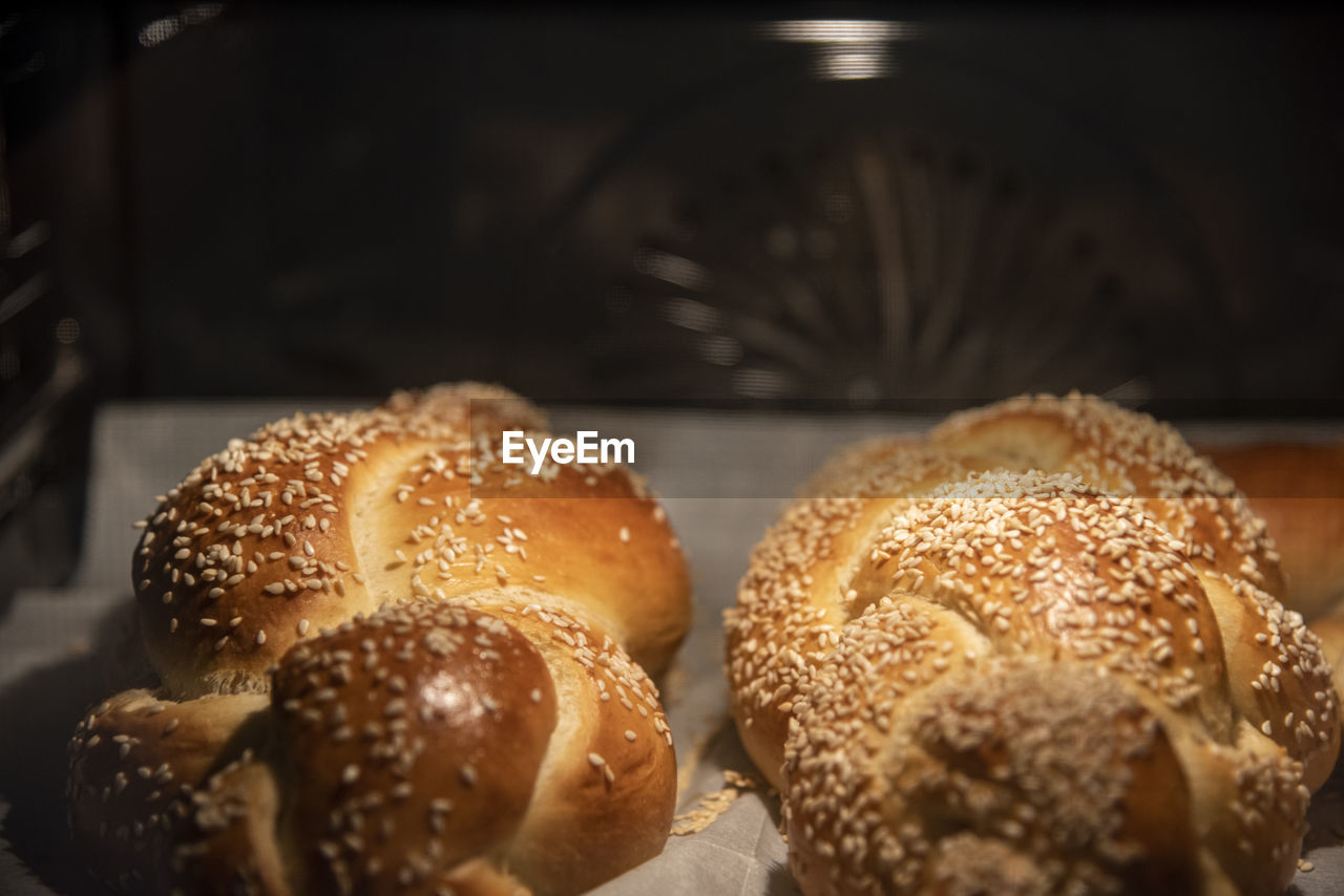 Baking homemade challah bread. braid challah with sesame seeds on a baking sheet in the oven