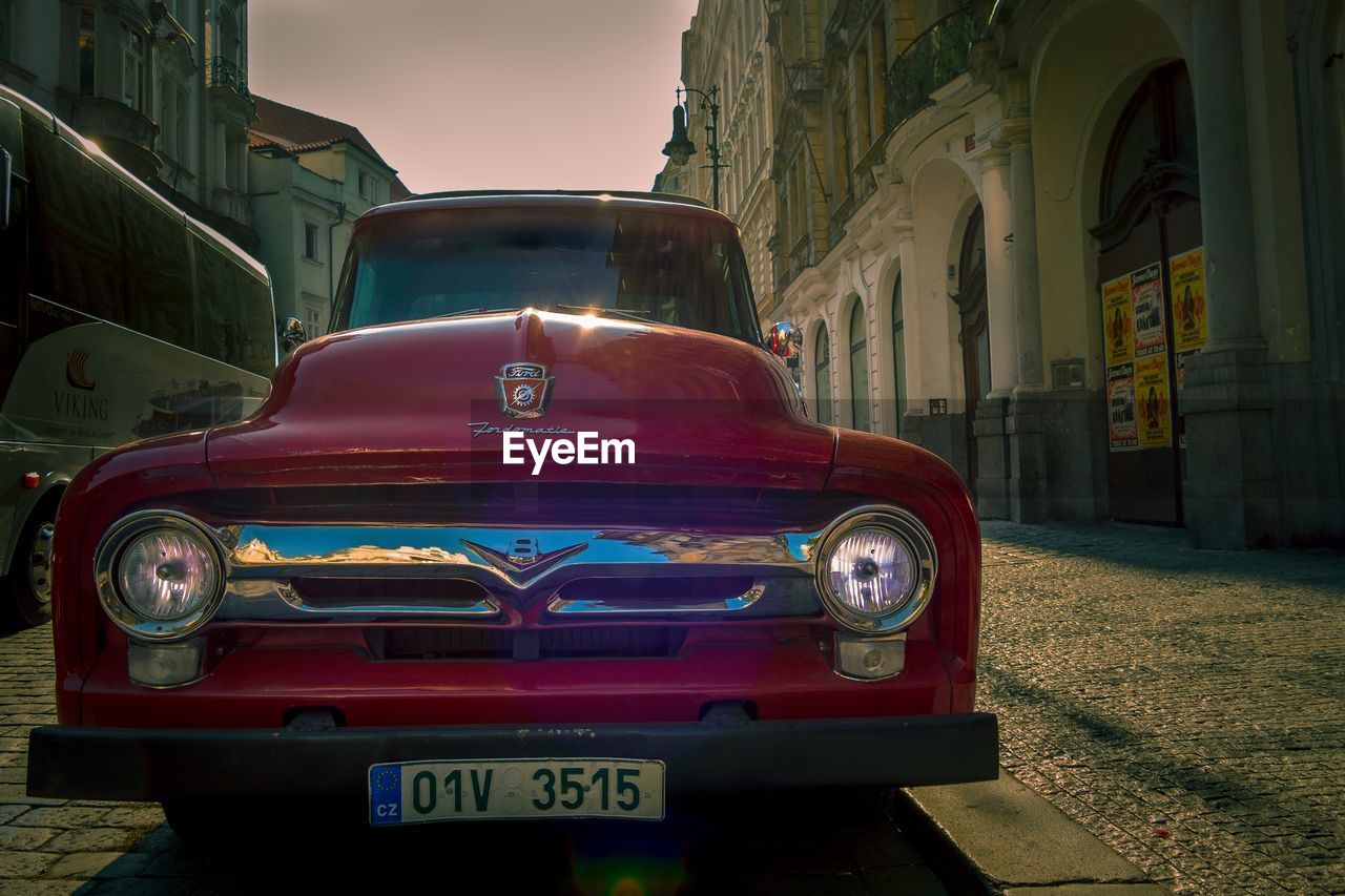 VINTAGE CAR ON STREET AGAINST BUILDINGS