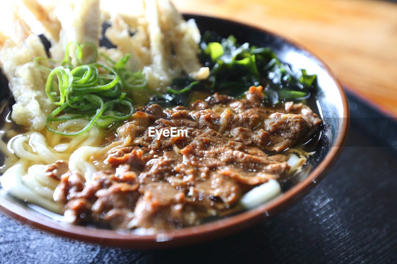 Udon noodles served in bowl on tray