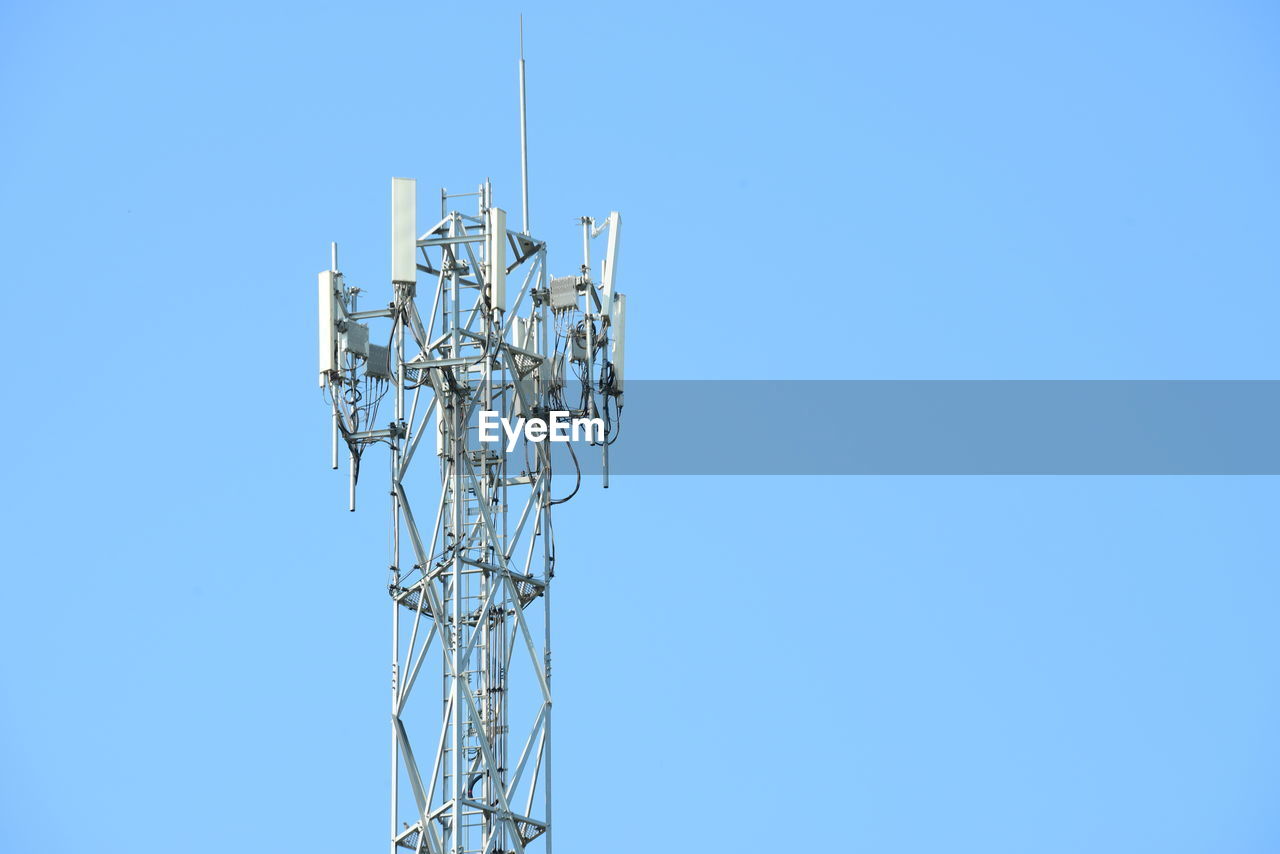 Low angle view of communications tower against clear blue sky