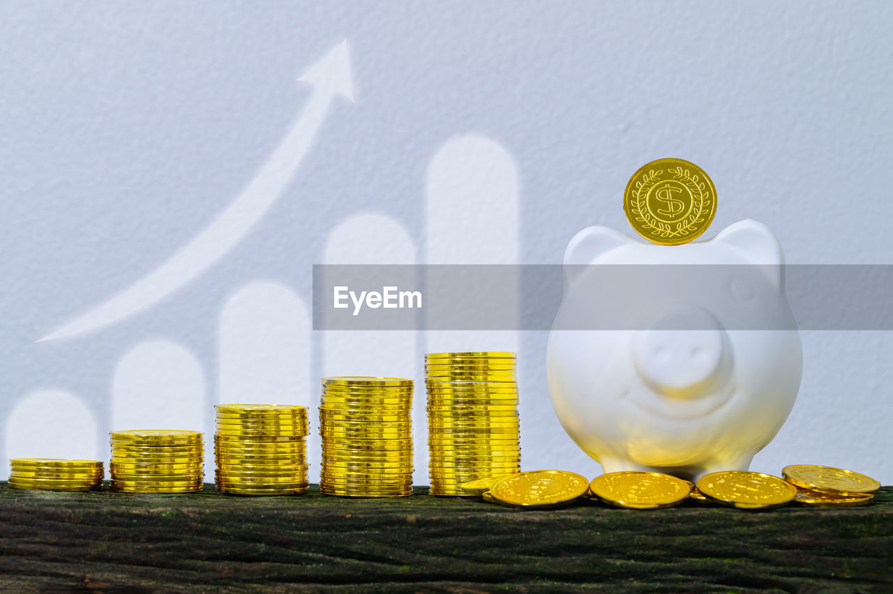 CLOSE-UP OF COINS ON TABLE AGAINST WALL