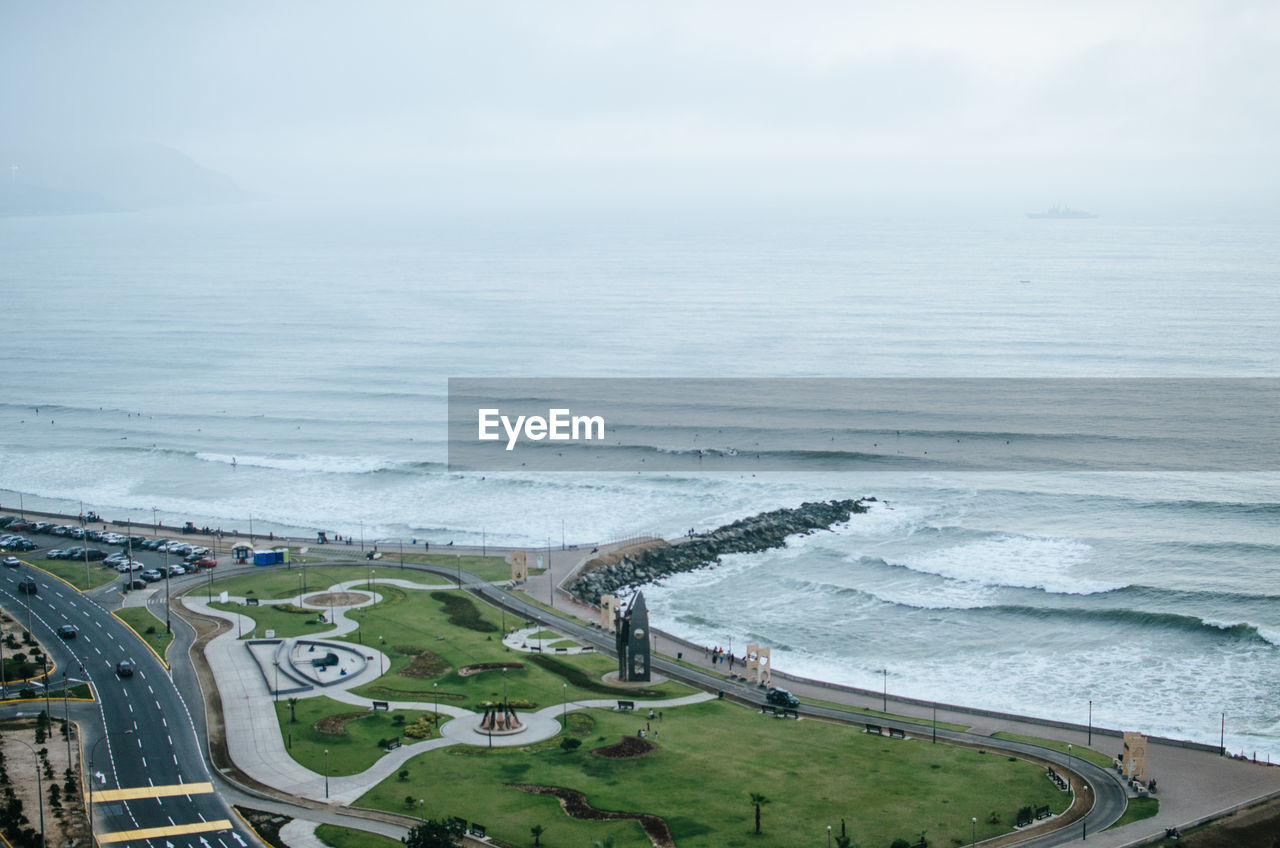 Aerial view of road by sea against sky