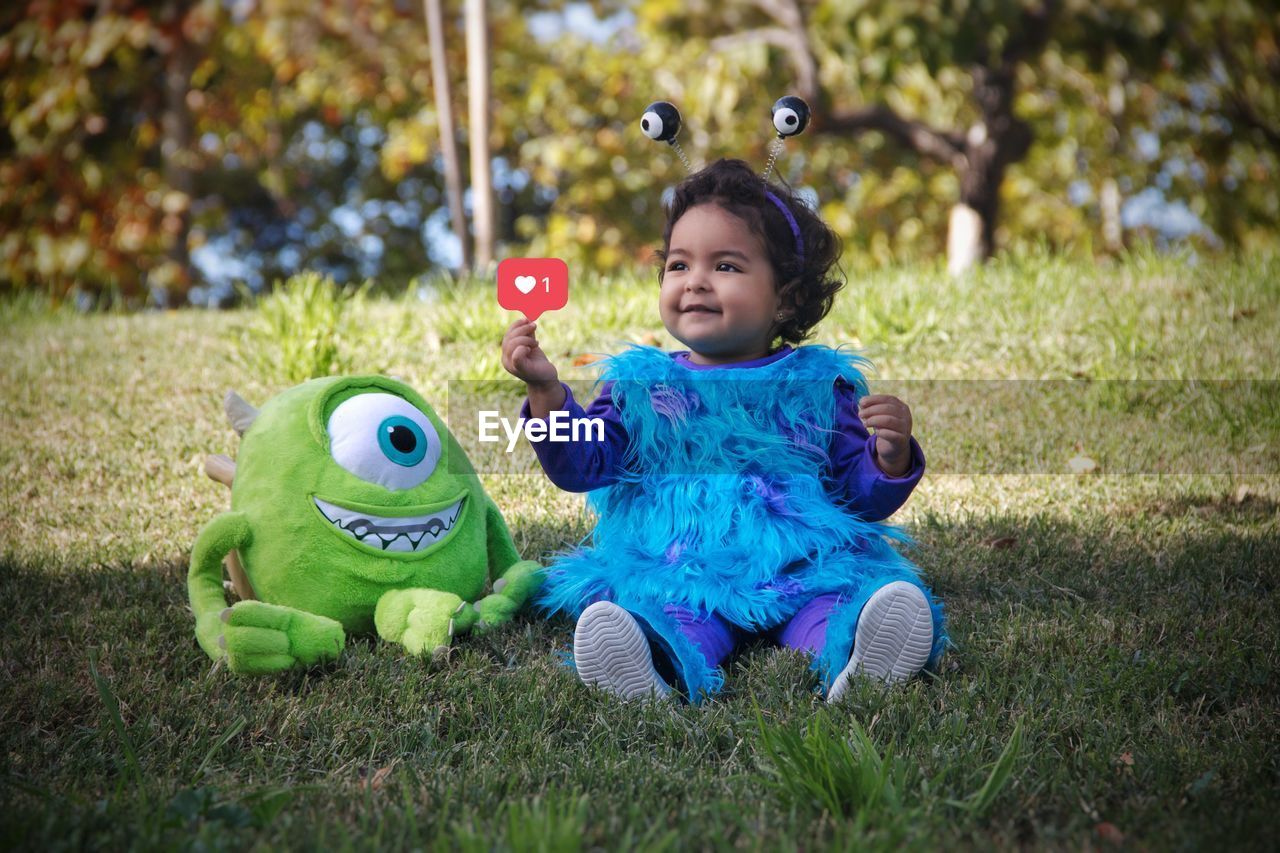 PORTRAIT OF SMILING GIRL PLAYING WITH TOY