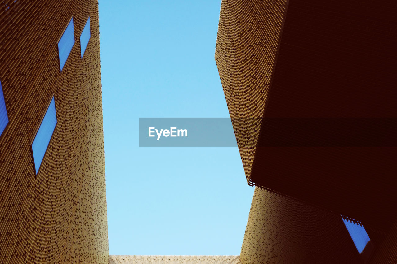 LOW ANGLE VIEW OF BUILDINGS AGAINST CLEAR BLUE SKY