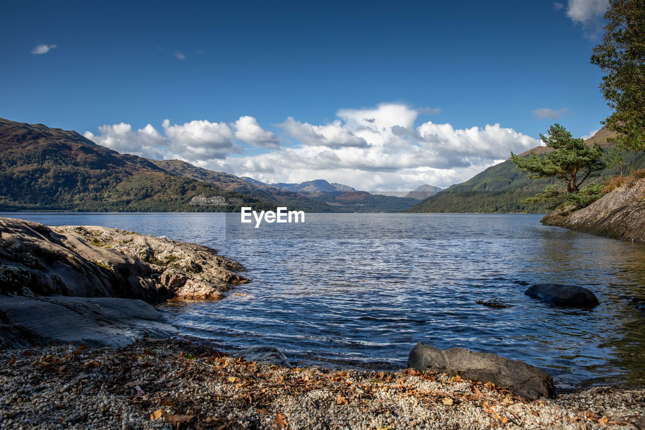 SCENIC VIEW OF LAKE BY MOUNTAIN AGAINST SKY