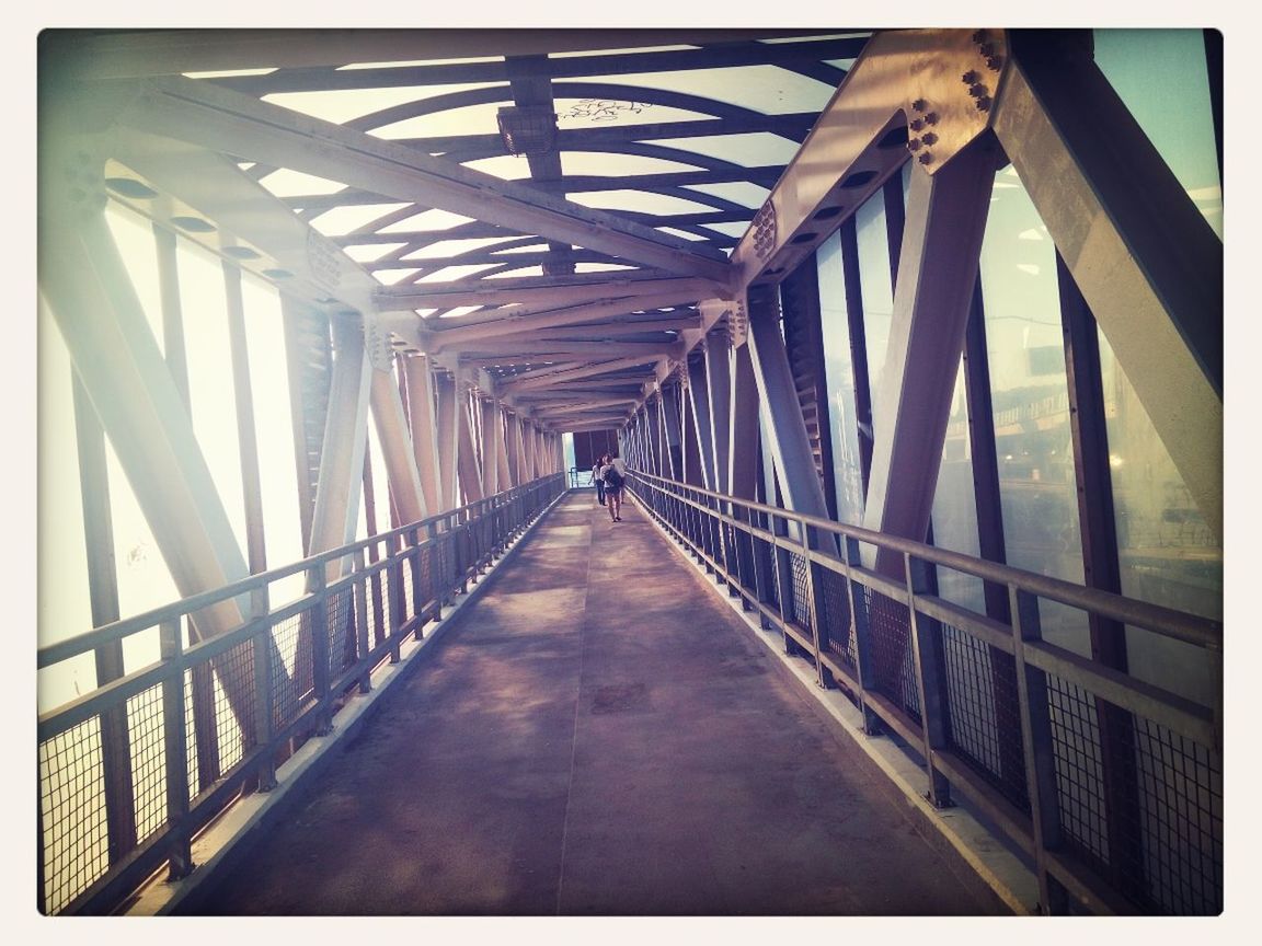 Empty covered footbridge along railings